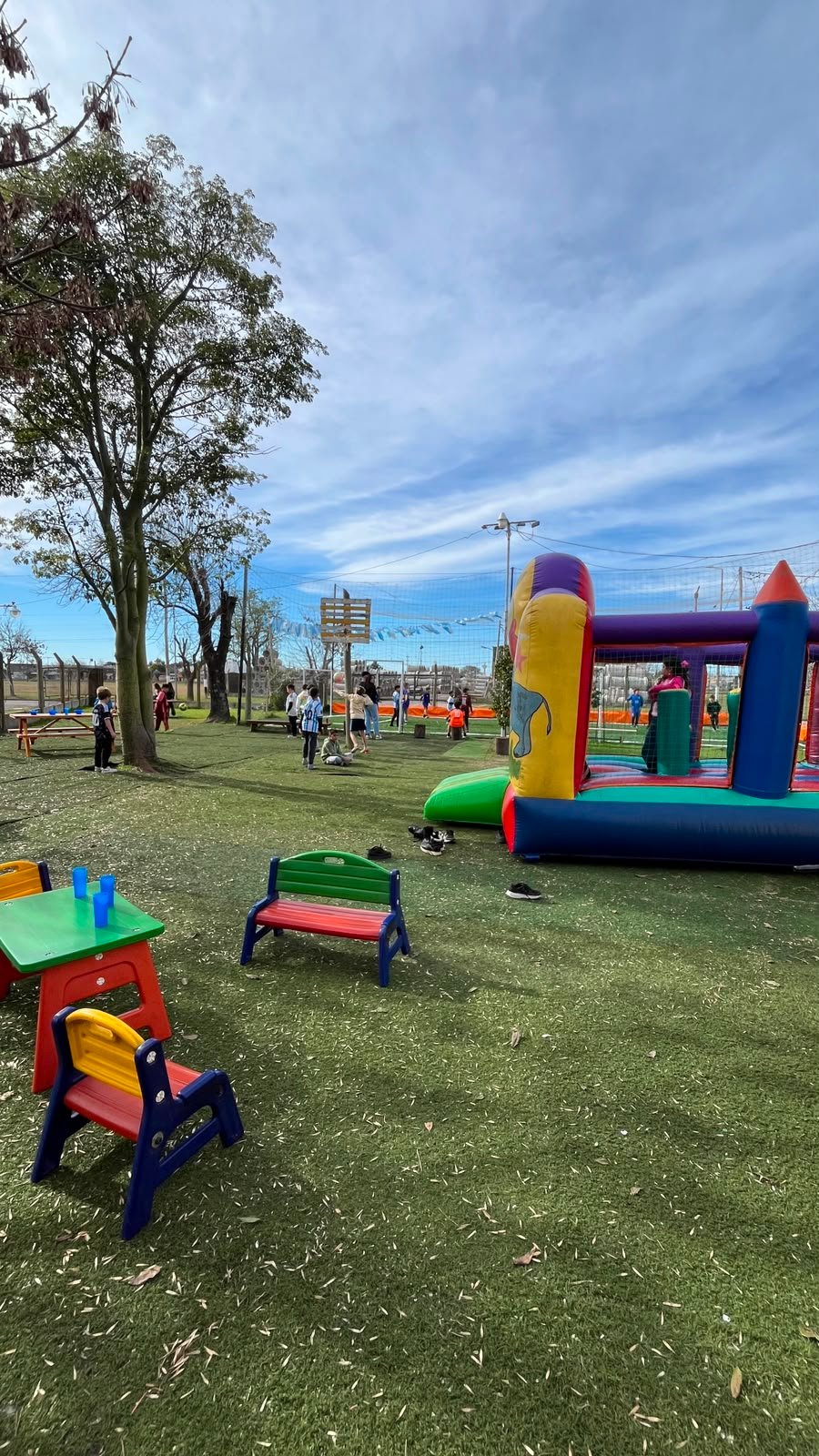 Patio verde con inflable y mesas