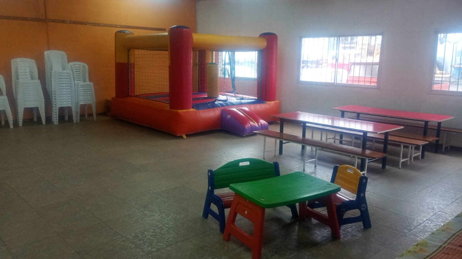Salón interior con inflable y mesas